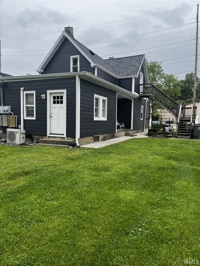2728 W Virginia Ave, Evansville, IN 47712 - back of property with stairway, a yard, ac unit, a chimney, and a shingled roof