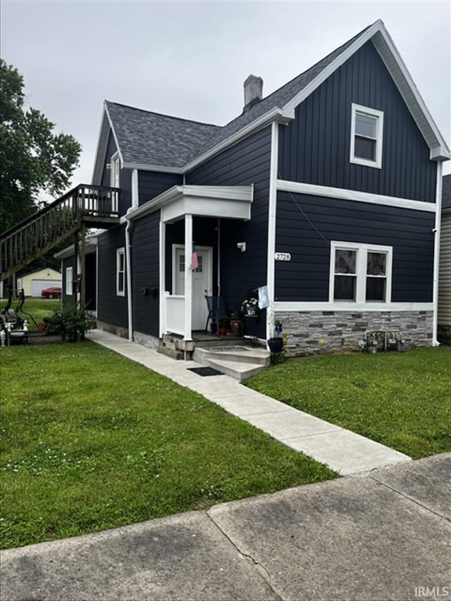 2728 W Virginia Ave, Evansville, IN 47712 - view of front of home featuring a front yard, a chimney, roof with shingles, stone siding, and a wooden deck