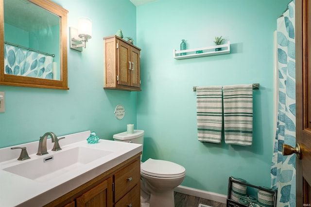51410 Mansfield Dr, South Bend, IN 46628 - bathroom with vanity, toilet, wood finished floors, and baseboards
