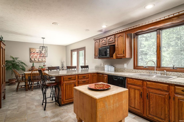 51410 Mansfield Dr, South Bend, IN 46628 - kitchen featuring black appliances, a sink, a peninsula, a breakfast bar, and pendant lighting