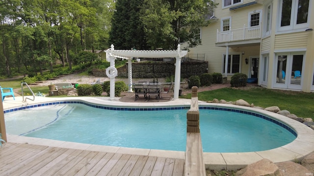 3043 N 400 E Xrd, Monticello, IN 47960 - swimming pool with a pergola, outdoor dining space, a wooden deck, a lawn, and a patio area