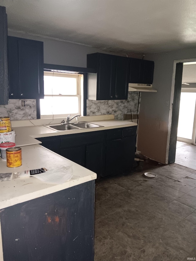 89 Mason St, Bedford, IN 47421 - kitchen featuring a sink, under cabinet range hood, light countertops, dark cabinetry, and backsplash