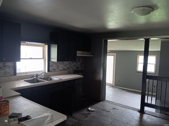 89 Mason St, Bedford, IN 47421 - kitchen featuring a sink, light countertops, a textured ceiling, under cabinet range hood, and backsplash