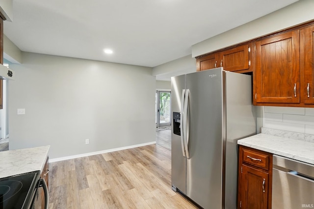 9820 Gerig Rd, Leo, IN 46765 - kitchen featuring stainless steel appliances, light wood-style flooring, light countertops, brown cabinets, and backsplash