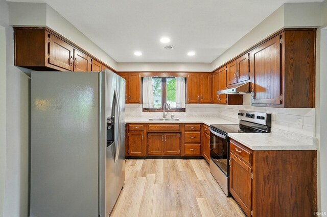 9820 Gerig Rd, Leo, IN 46765 - kitchen featuring appliances with stainless steel finishes, a sink, under cabinet range hood, light wood finished floors, and light countertops