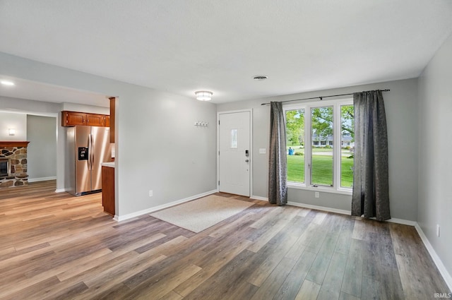 9820 Gerig Rd, Leo, IN 46765 - entryway featuring light wood-style flooring, baseboards, and a stone fireplace