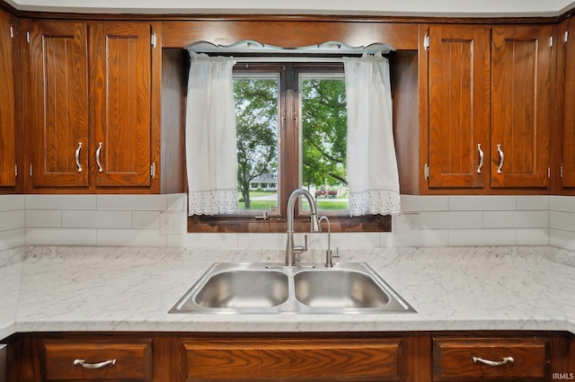 9820 Gerig Rd, Leo, IN 46765 - kitchen featuring a sink, backsplash, and brown cabinets