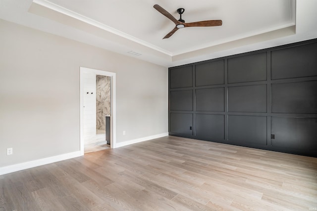 1256 Cascata Trl, Huntertown, IN 46748 - unfurnished bedroom with a raised ceiling, light wood-style floors, a decorative wall, crown molding, and a ceiling fan