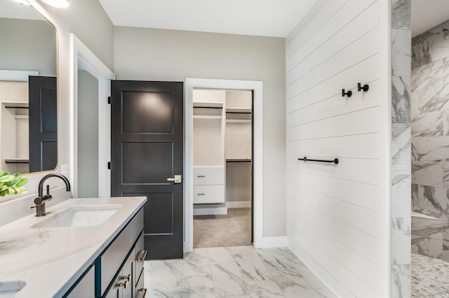 1256 Cascata Trl, Huntertown, IN 46748 - full bathroom featuring marble look tile flooring, double vanity, a walk in shower, a spacious closet, and wood walls