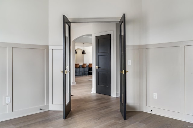 1256 Cascata Trl, Huntertown, IN 46748 - unfurnished bedroom with a decorative wall, arched walkways, wood finished floors, and wainscoting