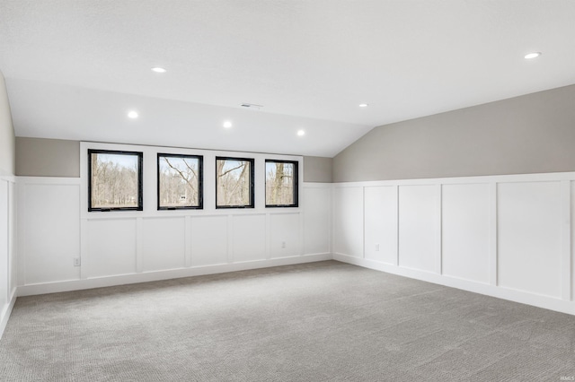 1256 Cascata Trl, Huntertown, IN 46748 - unfurnished room with a decorative wall, light carpet, lofted ceiling, recessed lighting, and wainscoting
