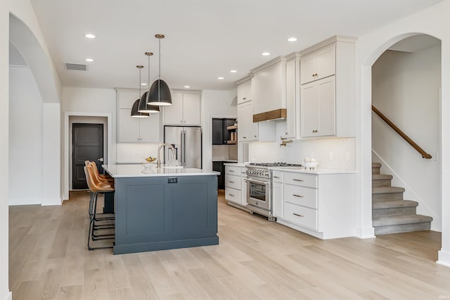 1256 Cascata Trl, Huntertown, IN 46748 - kitchen with high quality appliances, light countertops, light wood finished floors, decorative backsplash, and decorative light fixtures