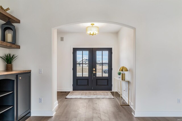 1256 Cascata Trl, Huntertown, IN 46748 - foyer entrance with arched walkways, dark wood-style floors, baseboards, and french doors