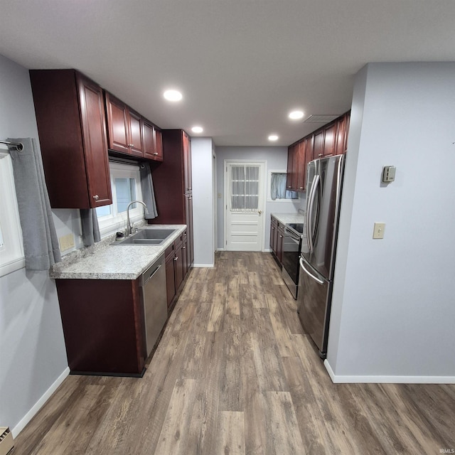 407 W N St, Winchester, IN 47394 - kitchen with stainless steel appliances, a sink, reddish brown cabinets, wood finished floors, and recessed lighting