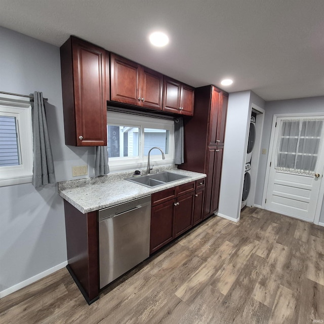 407 W N St, Winchester, IN 47394 - kitchen with dishwasher, a sink, stacked washer / dryer, light countertops, and reddish brown cabinets