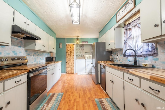 3907 N Caldwell Rd, Paragon, IN 46166 - kitchen featuring appliances with stainless steel finishes, washing machine and clothes dryer, under cabinet range hood, butcher block countertops, and a textured ceiling