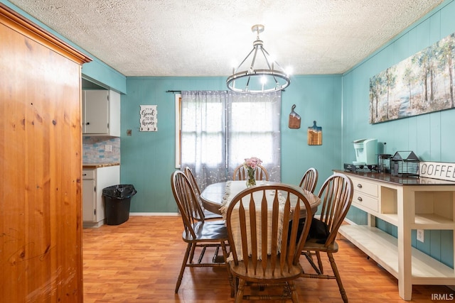 3907 N Caldwell Rd, Paragon, IN 46166 - dining space featuring light wood finished floors, a textured ceiling, a chandelier, and baseboards