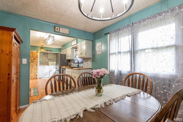3907 N Caldwell Rd, Paragon, IN 46166 - dining room with wood finished floors, a textured ceiling, and washer and dryer