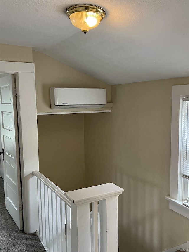 1016 Shore Dr, Fort Wayne, IN 46805 - hall featuring an AC wall unit, vaulted ceiling, carpet floors, and an upstairs landing