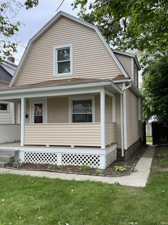 1016 Shore Dr, Fort Wayne, IN 46805 - colonial inspired home with a porch, a gambrel roof, a shingled roof, and a front lawn