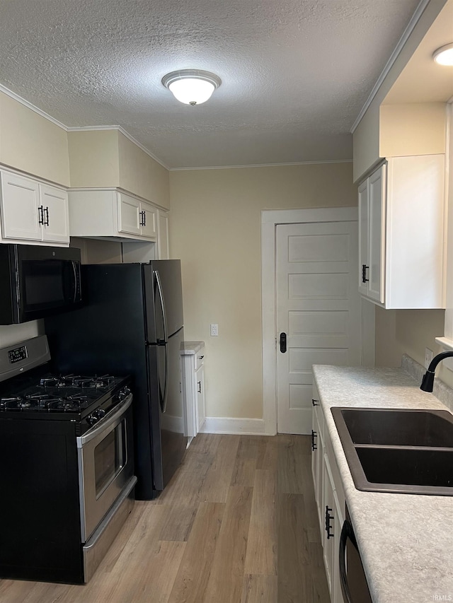1016 Shore Dr, Fort Wayne, IN 46805 - kitchen featuring black appliances, a sink, light wood-type flooring, a textured ceiling, and white cabinets