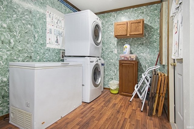 13495 N Hillside Dr, Syracuse, IN 46567 - laundry room with wallpapered walls, stacked washer / drying machine, wood finished floors, and cabinet space