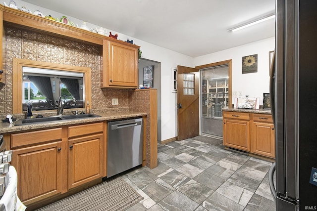 13495 N Hillside Dr, Syracuse, IN 46567 - kitchen with stainless steel appliances, a sink, backsplash, brown cabinets, and baseboards