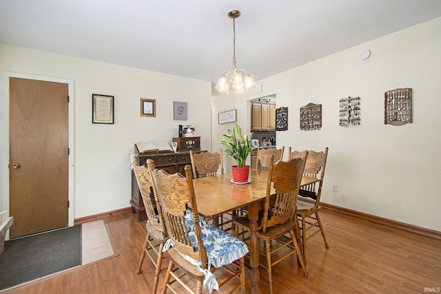13495 N Hillside Dr, Syracuse, IN 46567 - dining space featuring light wood finished floors, a chandelier, and baseboards