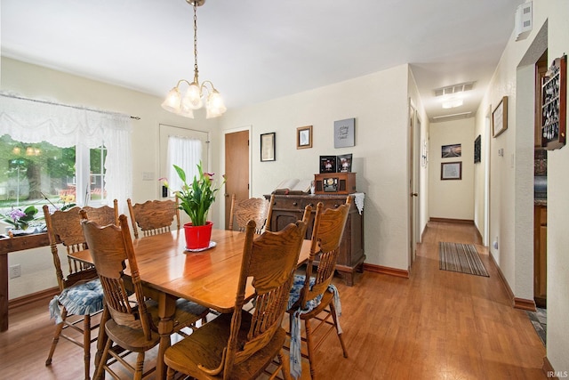 13495 N Hillside Dr, Syracuse, IN 46567 - dining space featuring light wood-style floors, a chandelier, and baseboards