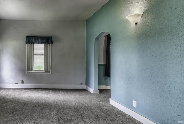 411 E Silver St, Bluffton, IN 46714 - empty room featuring arched walkways, carpet flooring, and baseboards