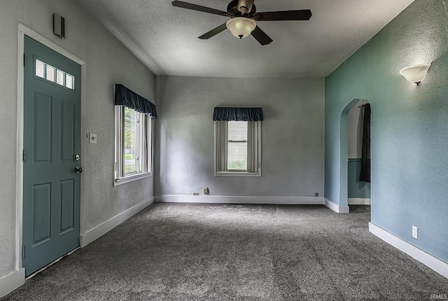 411 E Silver St, Bluffton, IN 46714 - carpeted entryway featuring healthy amount of natural light, arched walkways, a ceiling fan, a textured wall, and baseboards