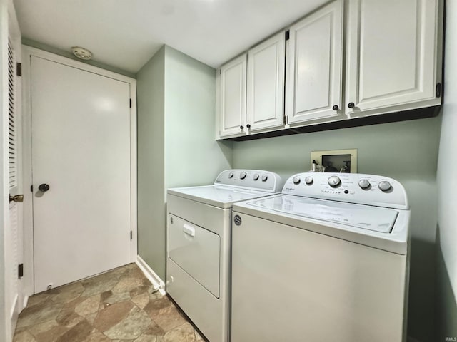 408 E Greenwalt St, North Webster, IN 46555 - laundry room featuring cabinet space, washing machine and clothes dryer, stone finish floors, and baseboards