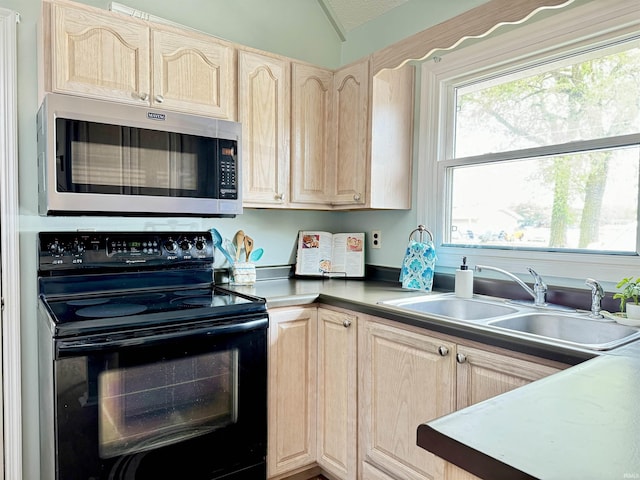 408 E Greenwalt St, North Webster, IN 46555 - kitchen with stainless steel microwave, black range with electric stovetop, light brown cabinets, a sink, and lofted ceiling