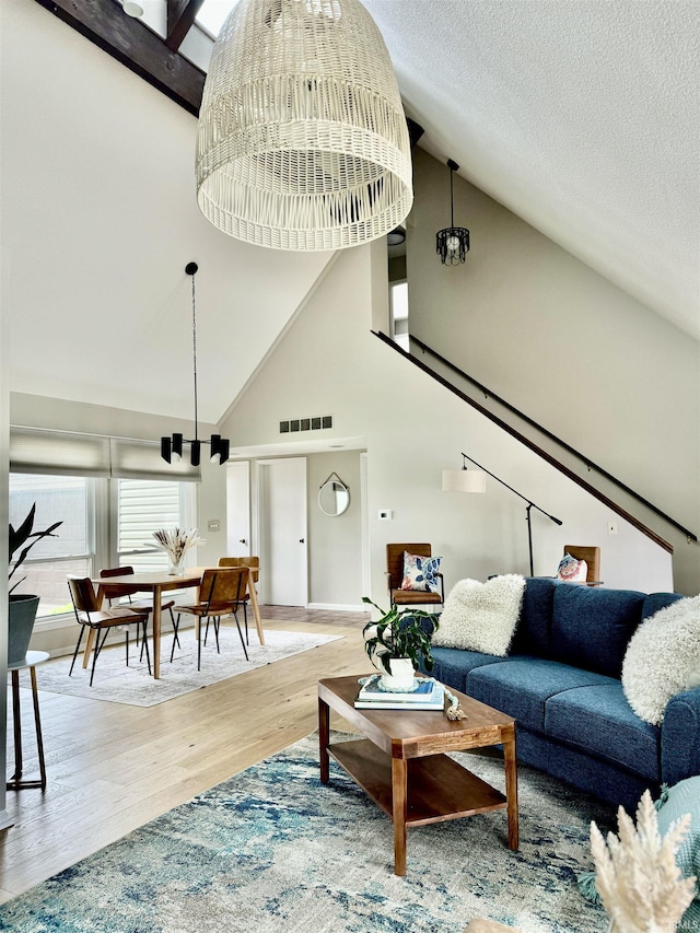 408 E Greenwalt St, North Webster, IN 46555 - living room with high vaulted ceiling, a chandelier, wood finished floors, and a textured ceiling