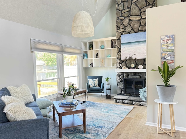 408 E Greenwalt St, North Webster, IN 46555 - living room featuring a fireplace, wood finished floors, lofted ceiling, and a textured ceiling
