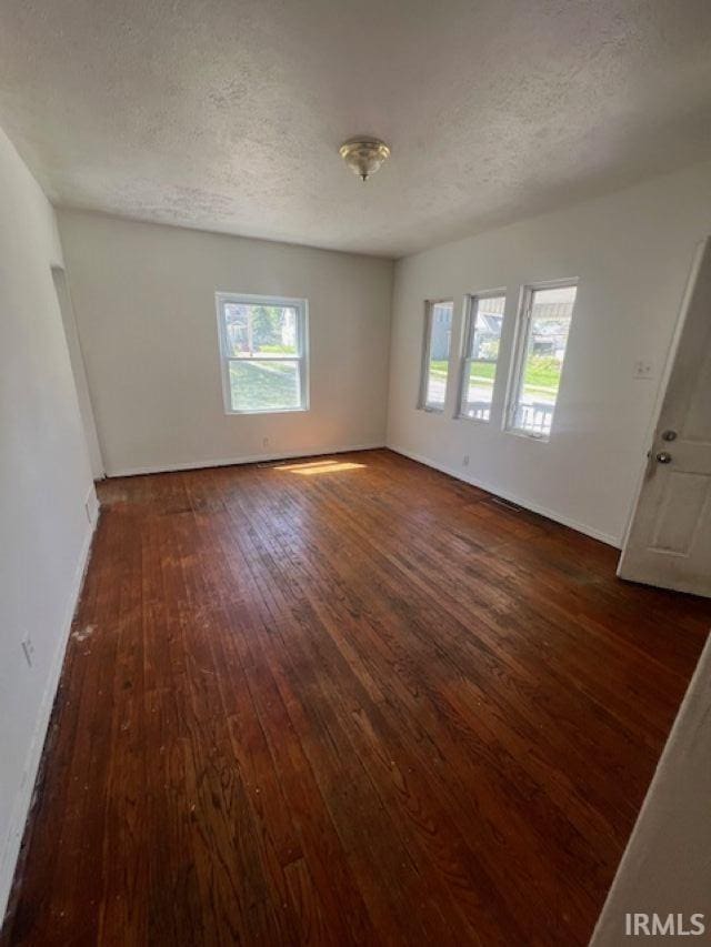 1512 Marine St, South Bend, IN 46613 - spare room with dark wood finished floors, a textured ceiling, and baseboards