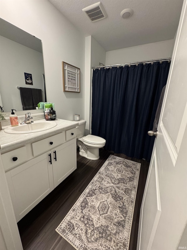 4855 Carson Ct, Woodburn, IN 46797 - full bathroom featuring vanity, wood finished floors, toilet, a textured ceiling, and a shower with shower curtain