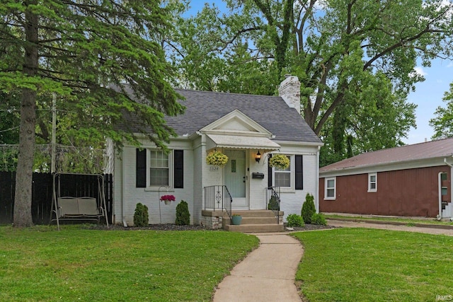 1324 Maple Ave, Fort Wayne, IN 46807 - view of front of house with a front yard, a chimney, and roof with shingles