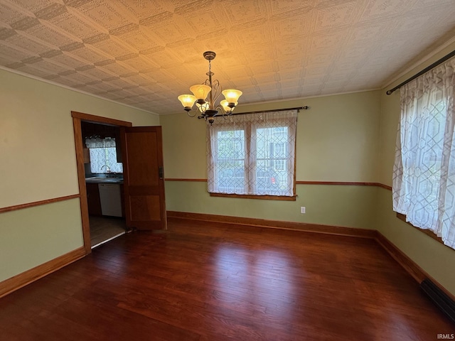 502 Keller St, North Judson, IN 46366 - unfurnished dining area with a chandelier, dark wood-style flooring, a sink, and baseboards