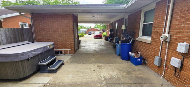 501 E Ulen St, Fort Branch, IN 47648 - view of patio / terrace with a hot tub, driveway, and an attached carport