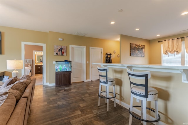5350 Cameo Dr, Evansville, IN 47711 - kitchen with dark wood-type flooring, a breakfast bar area, recessed lighting, light countertops, and baseboards