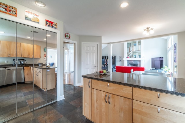 3513 Crater Cv, Fort Wayne, IN 46804 - kitchen with light brown cabinets, stone tile flooring, a fireplace, dark stone counters, and open floor plan
