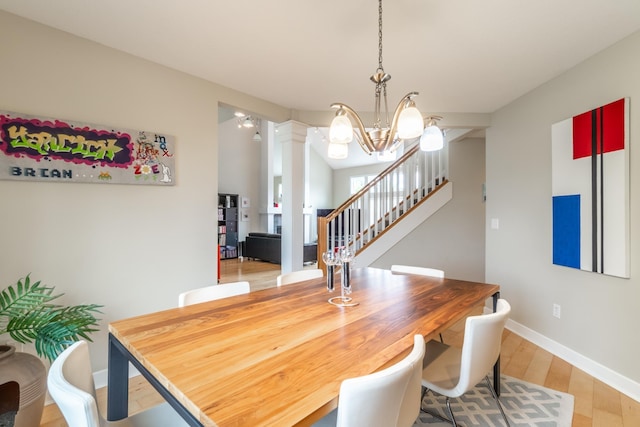3513 Crater Cv, Fort Wayne, IN 46804 - dining room with a chandelier, light wood-style flooring, stairs, baseboards, and decorative columns