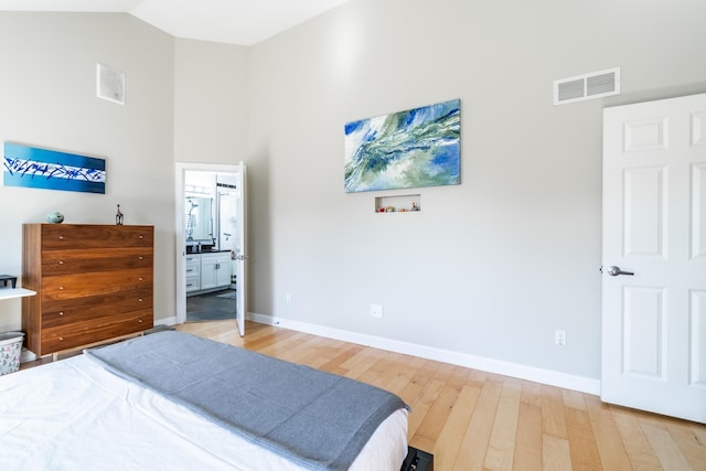 3513 Crater Cv, Fort Wayne, IN 46804 - bedroom with light wood-style flooring, baseboards, high vaulted ceiling, and connected bathroom