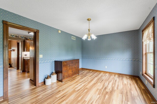 7800 E 400 S-92, Fort Wayne, IN 46818 - unfurnished dining area featuring wood finished floors, a chandelier, a textured ceiling, wallpapered walls, and baseboards