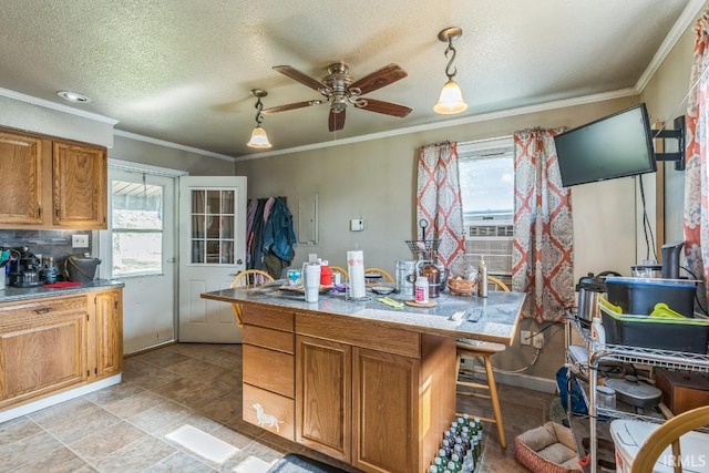 718 Center St, New Haven, IN 46774 - kitchen with healthy amount of natural light, ceiling fan, brown cabinetry, decorative light fixtures, and crown molding