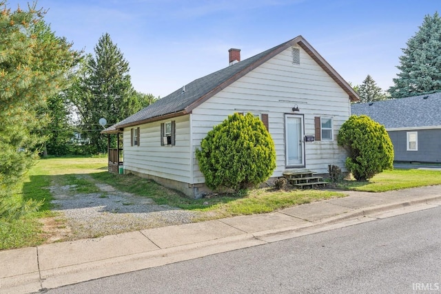 718 Center St, New Haven, IN 46774 - view of front of house featuring entry steps, a chimney, driveway, and roof with shingles