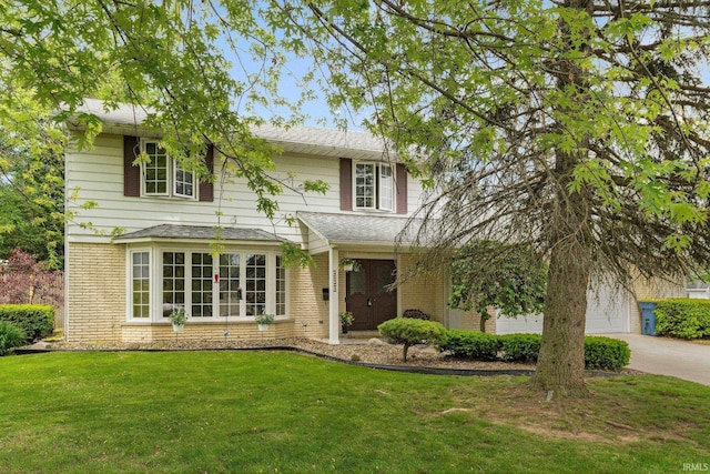 405 Inglenook Pl, Angola, IN 46703 - traditional-style home featuring brick siding, a front lawn, and concrete driveway