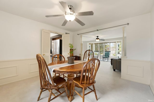 405 Inglenook Pl, Angola, IN 46703 - dining room with light colored carpet, a wainscoted wall, ceiling fan, and a decorative wall