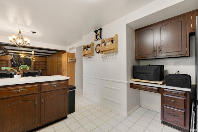 405 Inglenook Pl, Angola, IN 46703 - kitchen with light countertops, a chandelier, light tile patterned floors, dark brown cabinetry, and baseboards